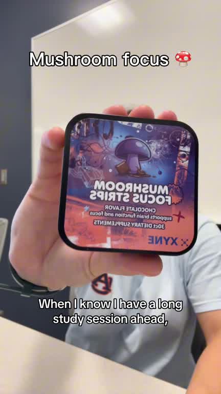 In a library, a student holds up the Mushroom Focus Strips tin and takes a strip